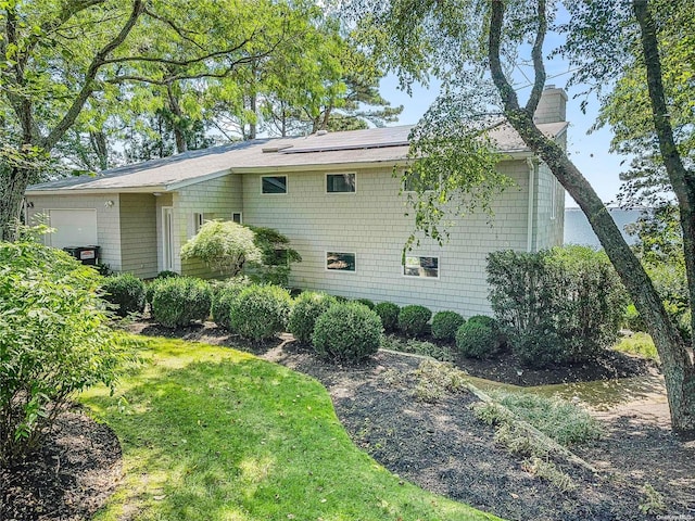 view of side of home with a yard