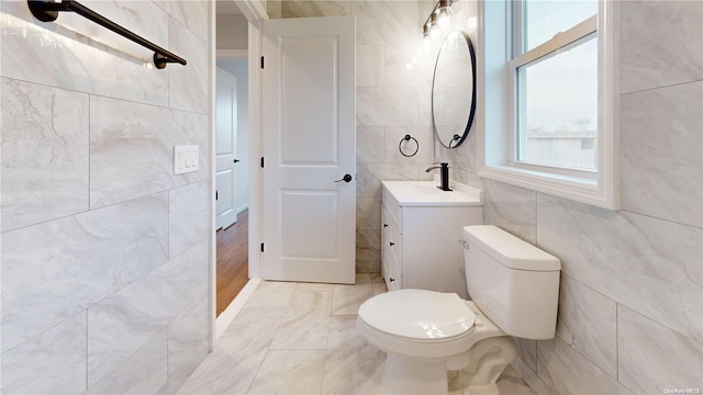 bathroom featuring tile walls, toilet, and vanity