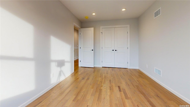 unfurnished bedroom featuring a closet and light wood-type flooring