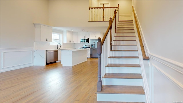 stairway with hardwood / wood-style flooring and sink