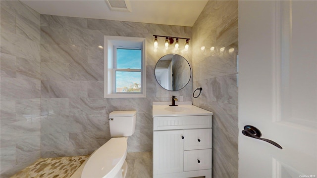 bathroom with toilet, tile walls, and vanity