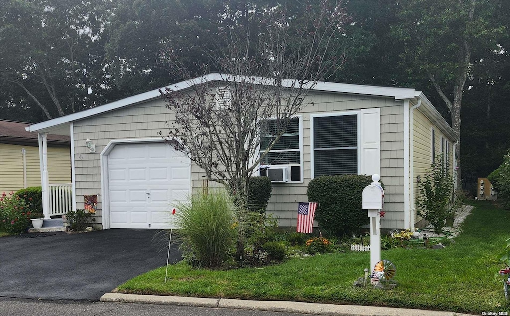 view of front facade featuring a garage, a front lawn, and cooling unit