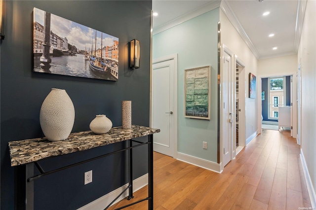 corridor featuring light wood-type flooring and ornamental molding