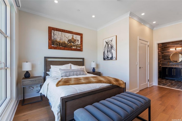 bedroom featuring dark hardwood / wood-style floors, ensuite bath, and crown molding