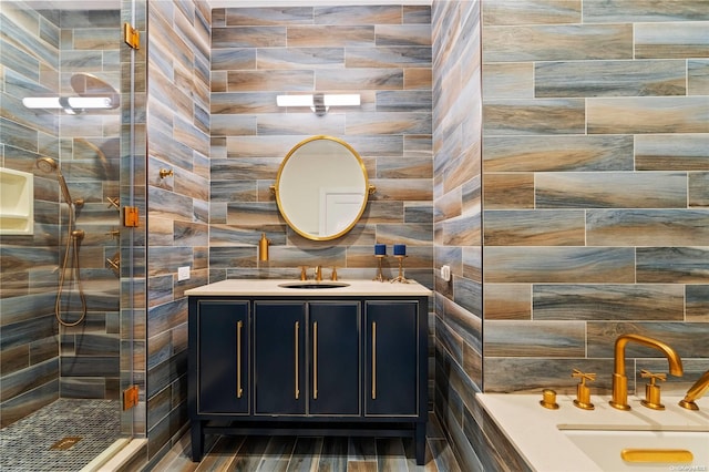 bathroom with a shower, vanity, and tile walls