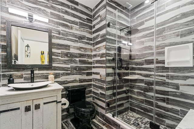 bathroom featuring toilet, vanity, tile walls, and walk in shower