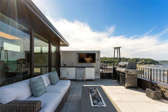 view of patio featuring an outdoor living space, a water view, grilling area, and exterior kitchen