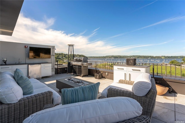 view of patio / terrace with sink, a water view, an outdoor living space with a fire pit, and a grill