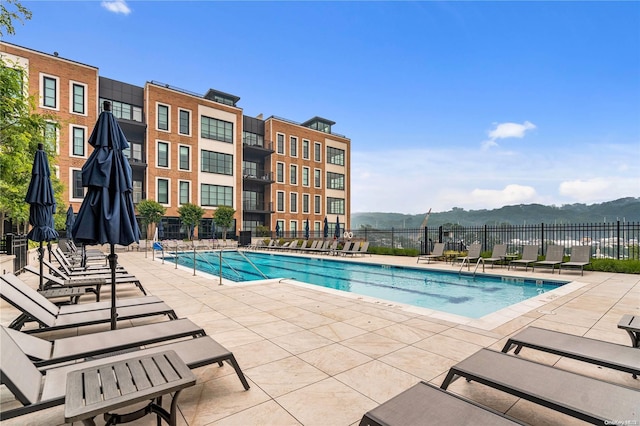 view of swimming pool with a mountain view and a patio