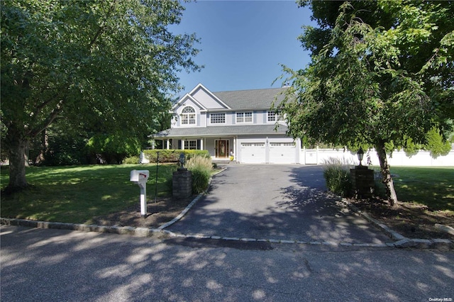 view of front of property with a front yard, a garage, and covered porch