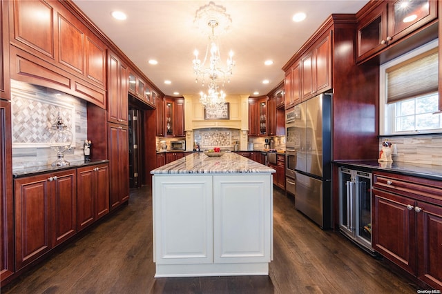 kitchen with beverage cooler, tasteful backsplash, dark stone countertops, stainless steel fridge, and decorative light fixtures