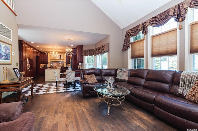 living room featuring plenty of natural light, dark hardwood / wood-style floors, high vaulted ceiling, and a chandelier
