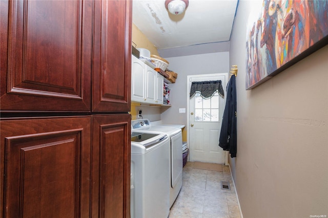 laundry area with cabinets and washer and clothes dryer