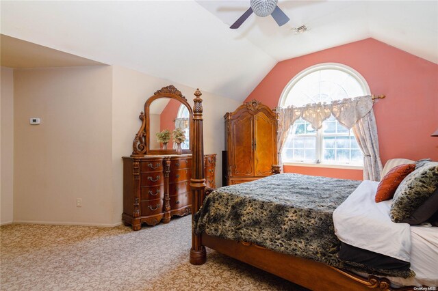 bedroom with ceiling fan, light colored carpet, and vaulted ceiling