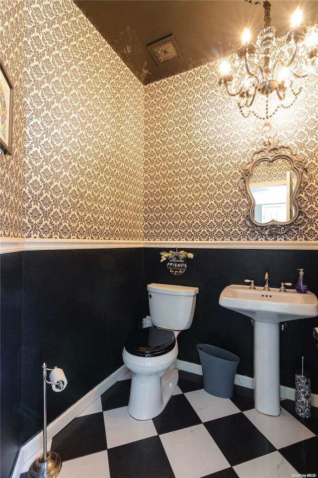 bathroom with a chandelier and toilet