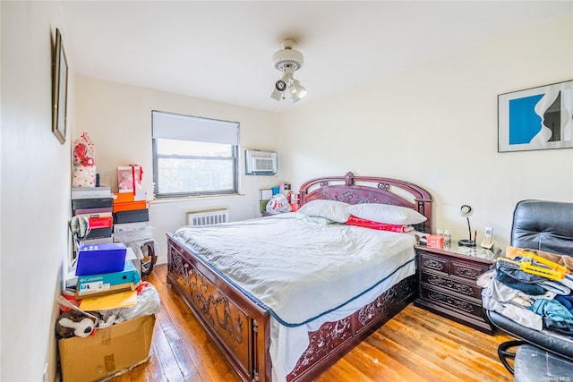 bedroom with a wall unit AC and hardwood / wood-style flooring