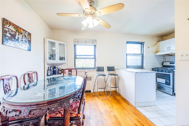 dining area with radiator, ceiling fan, and light hardwood / wood-style floors