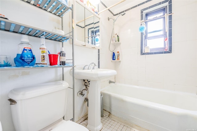 bathroom featuring tile patterned floors, tiled shower / bath, and toilet