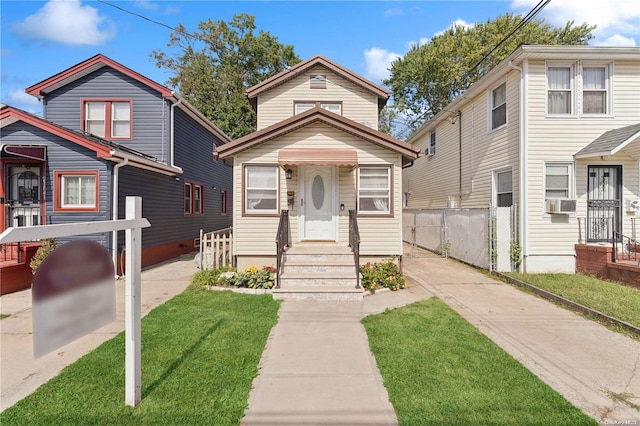 view of front of home featuring cooling unit and a front yard