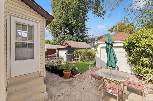 view of patio with a garage and an outbuilding