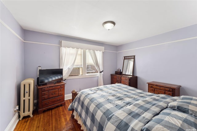 bedroom featuring radiator heating unit, cooling unit, and dark wood-type flooring