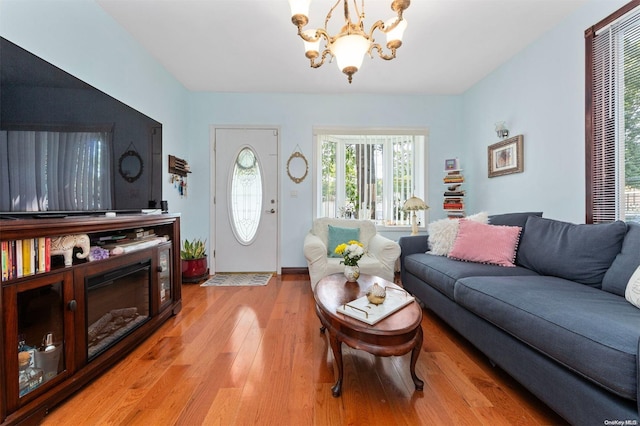 living room with an inviting chandelier and light hardwood / wood-style flooring