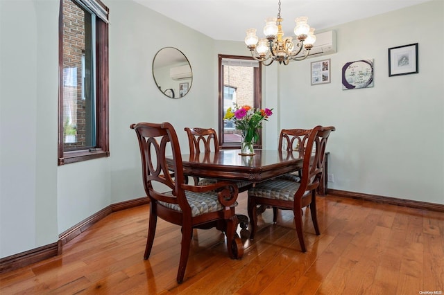 dining room with a notable chandelier, a healthy amount of sunlight, and light hardwood / wood-style flooring