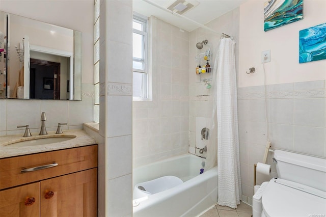 full bathroom with tile patterned flooring, toilet, shower / tub combo with curtain, vanity, and tile walls