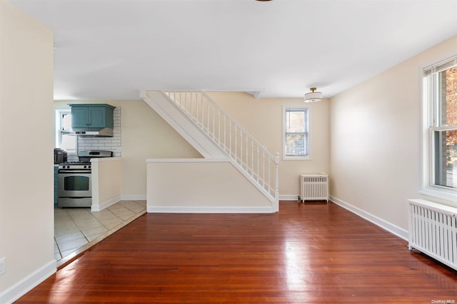 unfurnished living room featuring radiator heating unit and dark hardwood / wood-style floors