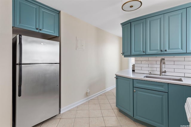 kitchen featuring blue cabinetry, stainless steel fridge, and sink