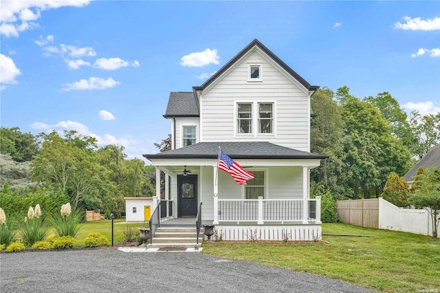 view of front facade featuring ceiling fan, covered porch, and a front yard