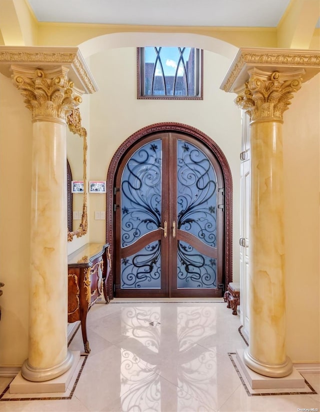 entryway with french doors, light tile patterned floors, and decorative columns