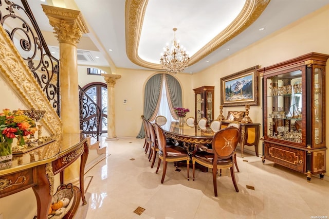 dining room with decorative columns, crown molding, a tray ceiling, and a notable chandelier