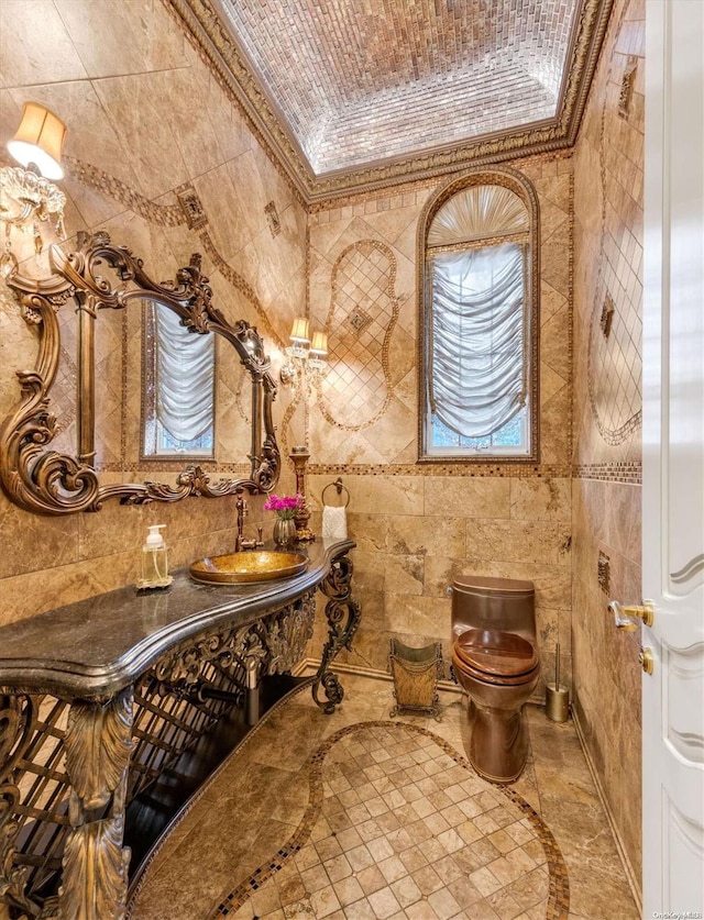 bathroom featuring crown molding, sink, tile walls, and toilet