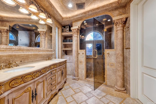 bathroom with vanity, ornate columns, and a shower with shower door