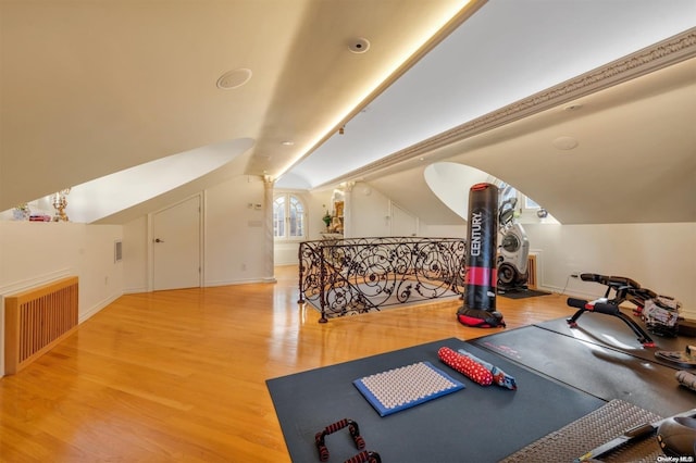 workout area with hardwood / wood-style floors, radiator, and vaulted ceiling