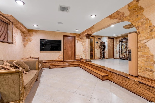 interior space with decorative columns and light tile patterned flooring