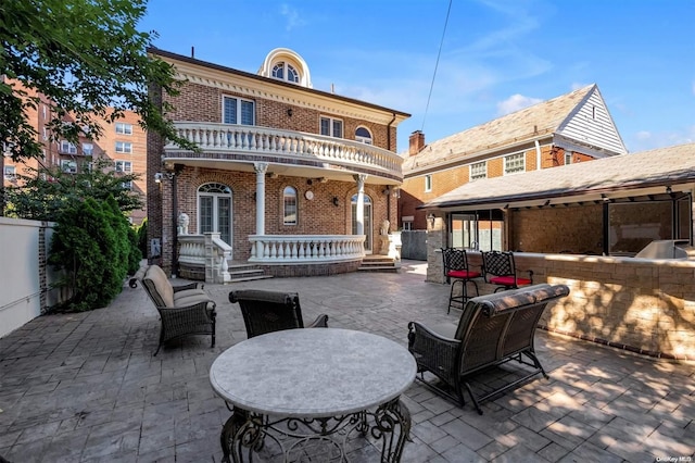 rear view of property featuring a patio area and a balcony