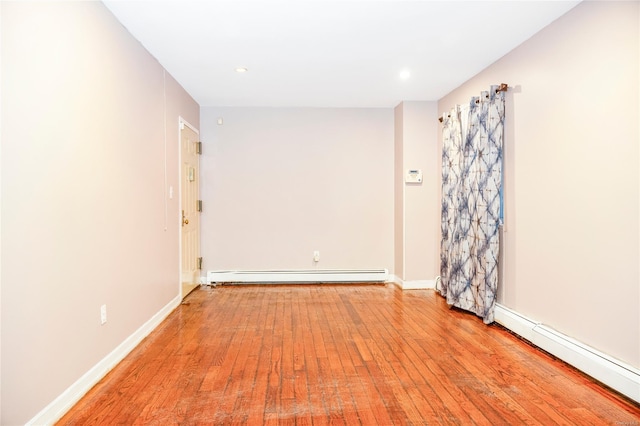 spare room with light wood-type flooring and baseboard heating