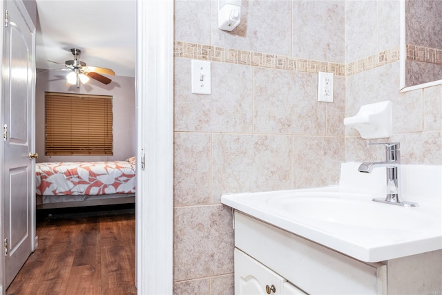 bathroom featuring ceiling fan, tile walls, hardwood / wood-style floors, and vanity