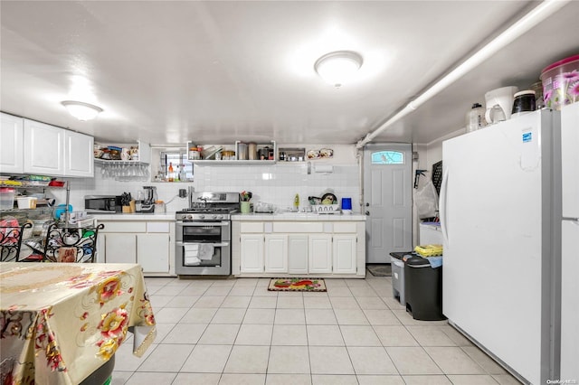 kitchen with backsplash, white cabinetry, light tile patterned floors, and stainless steel appliances