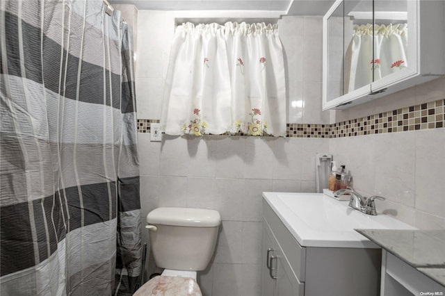 bathroom with walk in shower, vanity, toilet, and tile walls