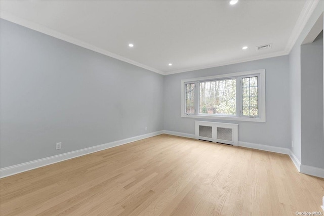 unfurnished room with crown molding, radiator heating unit, and light hardwood / wood-style flooring