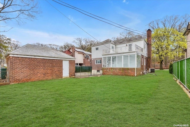 back of property with a balcony, a yard, and central AC