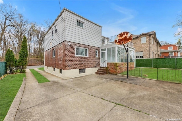 back of house featuring a lawn and a balcony