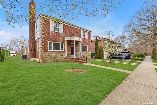 view of front of house featuring a balcony, a front lawn, and cooling unit