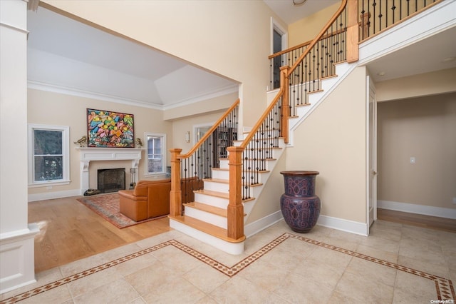 stairway with crown molding, hardwood / wood-style floors, and a towering ceiling