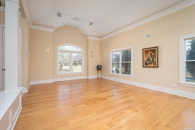 empty room with light hardwood / wood-style floors, ornamental molding, and vaulted ceiling