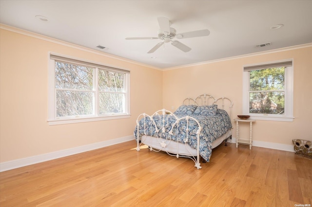 bedroom featuring light wood-type flooring, ceiling fan, and ornamental molding