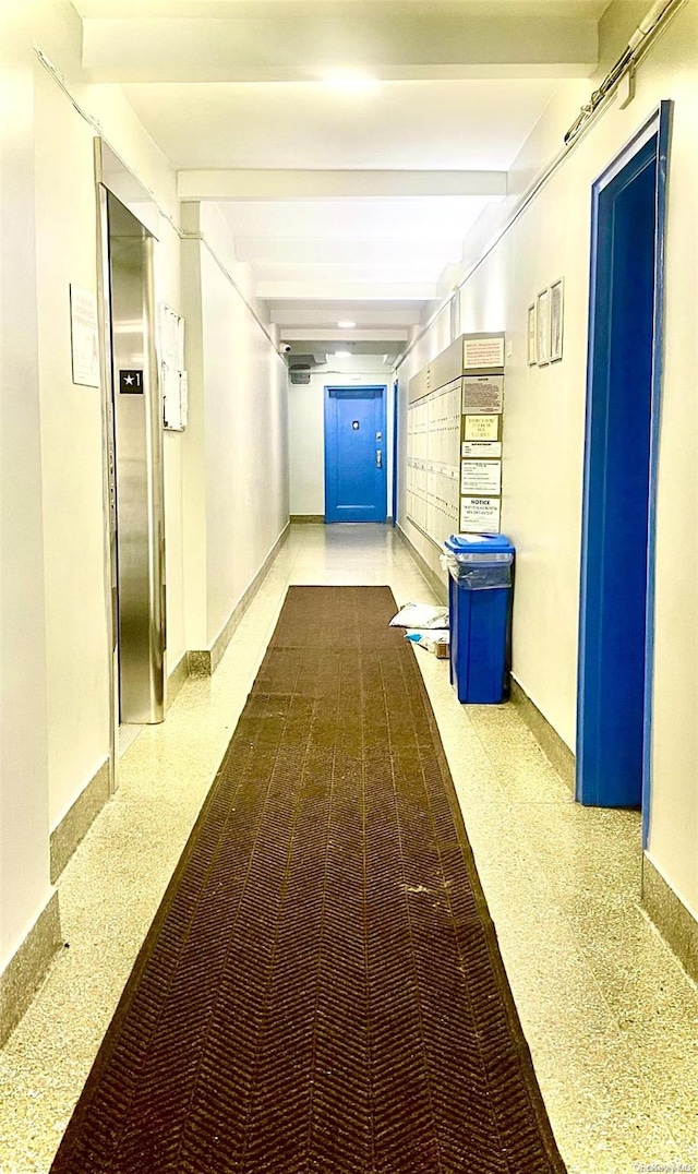 hallway with beamed ceiling and elevator